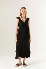 Vestido midi negro con cuello en V y volados en el escote y el ruedo.
