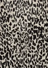 Blusa de tejido fluido color crema con estampado animal print negro, cuello en V y mangas largas abullonadas.
