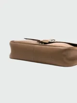 Cartera Longchamp Amazone de cuero color visón con solapa y cierre con hebilla metálica. Incluye correa de cuero ajustable y cadena metálica.
