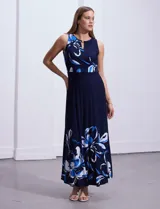 Vestido largo de punto color azul marino con estampado de flores blancas y celestes en el ruedo y en la parte superior.
