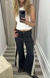 Pantalón ancho de jean celeste con paneles laterales en tela color camel con estampado sutil.