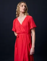 Vestido largo de gasa color rojo, con escote en V, mangas cortas con volados, cintura elastizada con lazo de ajuste y ruedo asimétrico con volados. Tiene forro interno a tono.