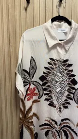 Vestido camisero corto color blanco con estampado de palmeras, flores y ananás.
