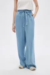 Pantalón de jean celeste, de corte ancho, con cintura elástica y cordón ajustable.