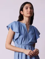 Vestido midi celeste de tencel con cuello a la base y escote en V. Cintura con frunces y lazo de ajuste. Terminación de ruedo con volado.
