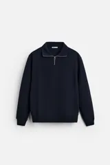 Sudadera azul marino de corte relaxed fit, cuello alto con cierre de cremallera frontal, manga larga y terminaciones en rib.