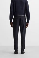 Pantalón slim fit negro confeccionado en tejido con elasticidad en ambas direcciones. Cuenta con bolsillos frontales y traseros de vivo con botón. Cierre frontal con cremallera y botón.