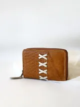 Billetera pequeña de cuero color camel con cierre metálico y diseño de cruces blancas. Incluye monedero interno.