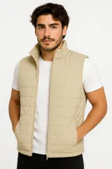 Chaleco acolchado color beige con cierre frontal y bolsillos laterales.