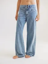 Pantalón de jean celeste de tiro medio alto, corte wide leg, con bolsillos delanteros y traseros.