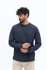 Remera de manga larga color negro, con escote redondo y un pequeño logo circular estampado en el pecho.