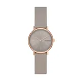Reloj Skagen Signatur Lille para mujer con caja redonda de acero inoxidable color oro rosa, esfera gris con agujas e indicadores minimalistas y correa de cuero gris.