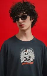 Remera negra de algodón con cuello redondo y calce oversize. Estampado frontal con diseño de calavera con sombrero de copa y personajes de Disney.