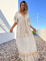 Vestido túnica largo de color celeste con bordados dorados y detalles de encaje en el escote y ruedo.
