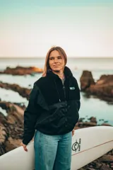 Campera negra con paneles de tela lisa y de corderito, cierre frontal y cuello alto.