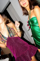 Vestido corto de lentejuelas color verde oliva, con escote en V, breteles finos cruzados en la espalda, cut-outs laterales y volado en el ruedo.