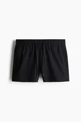 Short de baño negro de sirsaca con aberturas laterales cortas, cintura elástica con cordón ajustable, bolsillos laterales y bolsillo trasero con cierre autoadherente. Tiene suspensor interior de malla.