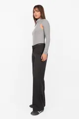 Body gris de tejido de punto con cuello alto y mangas largas. Presenta aberturas en los hombros y broches en la entrepierna.