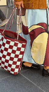 Bolso tipo tote de cuero tejido a mano con diseño a cuadros en color negro y tostado.