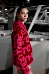 Cárdigan tejido de lana color borgoña con bordado de letras rosas que forman la frase "Good To Be Together". Tiene cuello redondo, cierre frontal con cremallera y calce holgado.