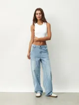 Pantalón de jean celeste, de corte ancho y tiro alto, con bolsillos laterales y traseros.