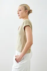 Remera color beige melange de corte clásico, con escote en V y mangas cortas con dobladillo.