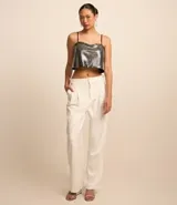 Blusa cropped metalizada con breteles finos ajustables y abertura en la espalda.