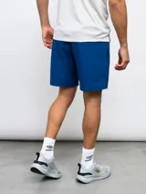 Short deportivo azul de entrenamiento, con pretina en contraste y logo de la marca en la pierna.