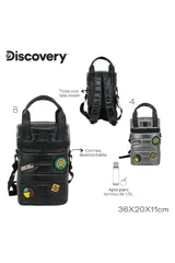 Mochila tipo bolso cilíndrico, acolchada y color negro, con asas superiores y correa ajustable para llevar al hombro. Presenta varios parches decorativos, incluyendo uno con coordenadas geográficas y otro con el texto "MAKE YOUR WORLD BIGGER".