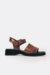 Sandalias de cuero color marrón con plataforma negra y hebilla lateral.