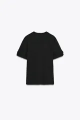 Camiseta negra de algodón con cuello redondo, manga corta y detalle de flores con volumen en las mangas.