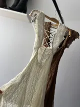 Vestido corto color marrón de encaje con escote cuadrado y mangas cortas.