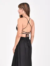 Vestido largo negro con escote pronunciado en V, tirantes finos y aberturas laterales en la cintura. La falda es larga y fluida.