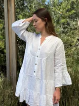 Vestido corto negro de lino, con escote en V, botones frontales y mangas largas acampanadas con volados.