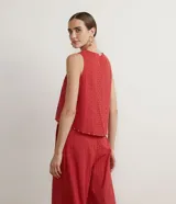 Blusa musculosa color ladrillo en tejido de laise texturizado, con cuello redondo, tirantes anchos y aplicación de canutillos de madera en la barra.