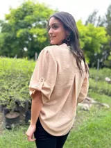 Blusa de lino color beige, con manga larga y diseño ligero.