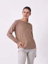 Remera de manga larga a rayas horizontales blancas y negras, con botones dorados en los hombros.