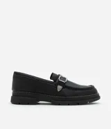 Zapato negro de cuero sintético con punta redonda, detalle de hebilla plateada y suela track.