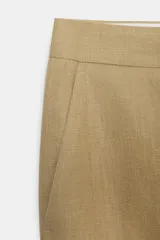 Pantalón de vestir color beige, de tiro alto, corte recto y largo cropped.