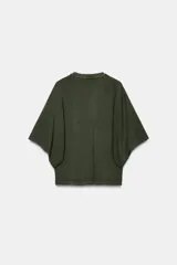 Camiseta blanca de manga corta con corte oversize y cuello redondo. El diseño presenta mangas amplias tipo capa que caen desde el hombro.