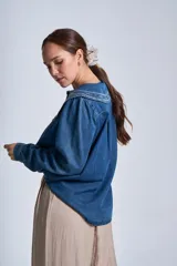 Camisa de jean celeste con cuello Claudine bordado en tonos tierra, de manga larga y corte recto.