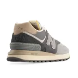 Championes New Balance 574 de caña baja, con capellada de gamuza gris, puntera de malla gris claro y logo "N" en cuero gris.