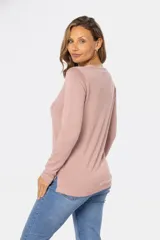 Buzo color beige de tejido de punto con bordado de pequeñas flores blancas.