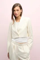 Blazer corto color blanco, de manga larga con solapa y bolsillo de pecho en tela brillosa.