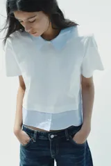 Camiseta blanca de cuello redondo con solapa combinada a contraste de rayas celestes. Manga corta. Bajo con tejido combinado de rayas celestes. Cierre en espalda con abertura y botón.