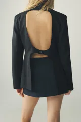 Falda pantalón corta color azul marino, de tiro medio, con abertura en el delantero y cierre lateral con cremallera oculta.