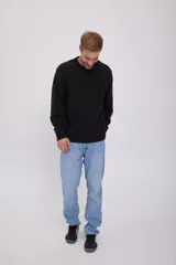 Sweater negro de punto con cuello redondo y mangas largas.