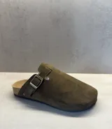 Sueco cerrado color verde oliva, estilo zueco tipo clog, con tira ajustable y hebilla metálica en el empeine. La suela es de corcho con base de goma oscura.