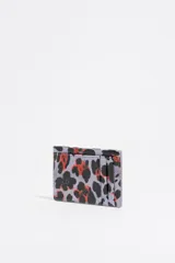 Tarjetero Bimba y Lola con estampado animal print en tonos lila, negro y naranja. Confeccionado en poliéster y poliuretano con logo metálico.