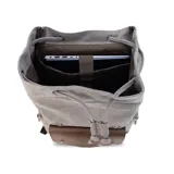 Mochila negra de tela canvas con detalles en símil cuero marrón, cierre superior marinero, bolsillos internos y externos con cierre metálico, asas rígidas y correas ajustables.
